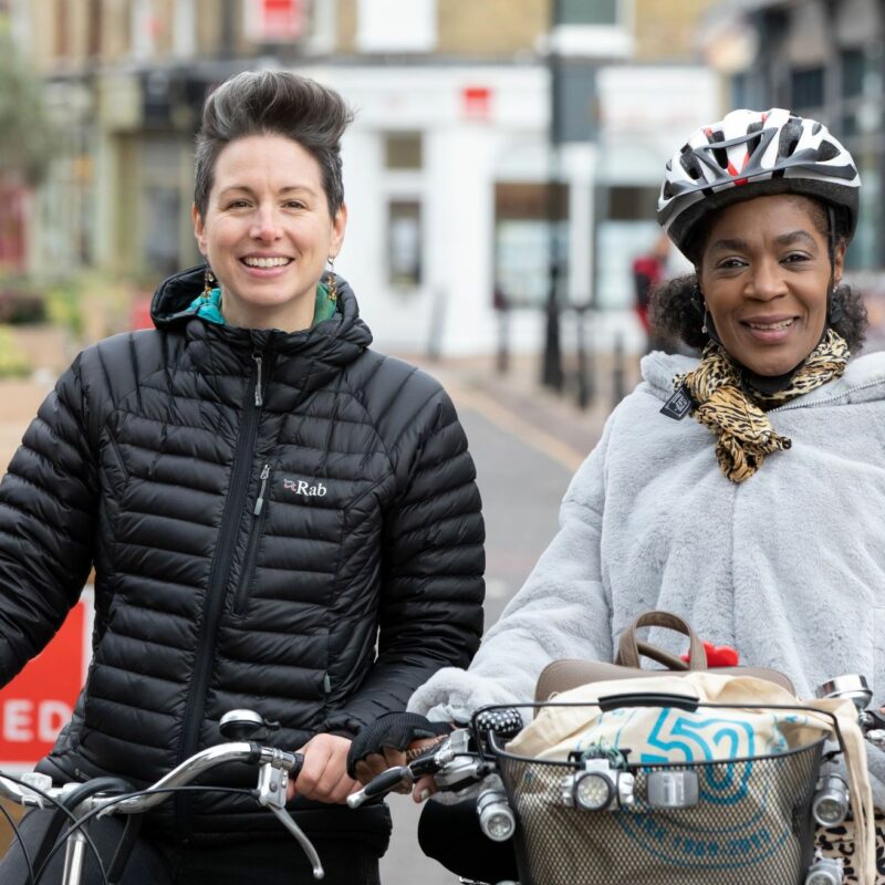 Trish and Jo - cycle buddies with bikes smiling