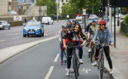 Woman smiling on bike on cycle lane (cycle superhighway)