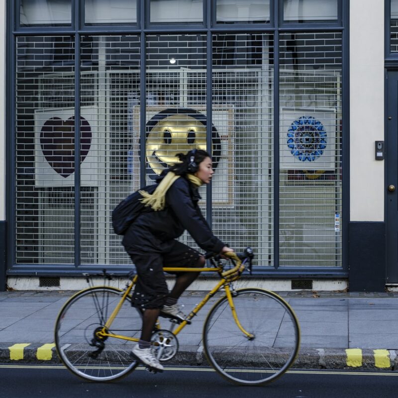 Women cycling on a yellow bike on a quiet road