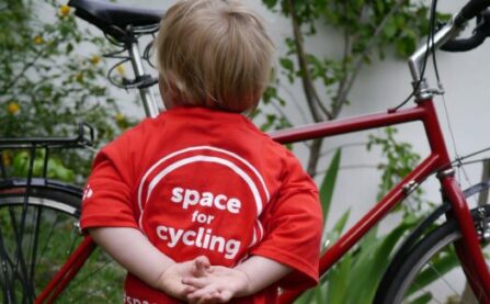 LCC child in t-shirt looking at bike
