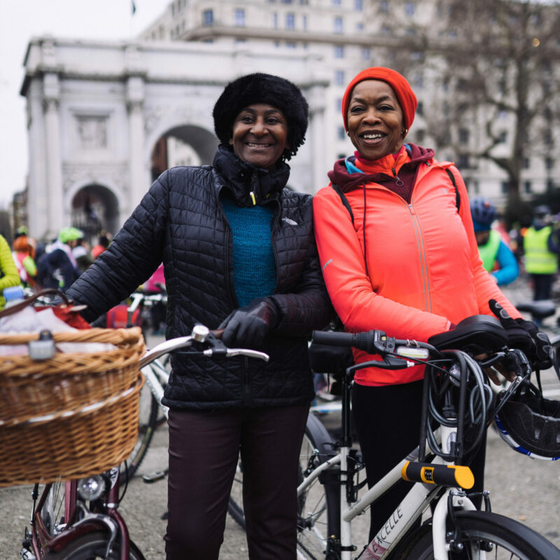 Woman with Dutch bike and basket standing next to friend