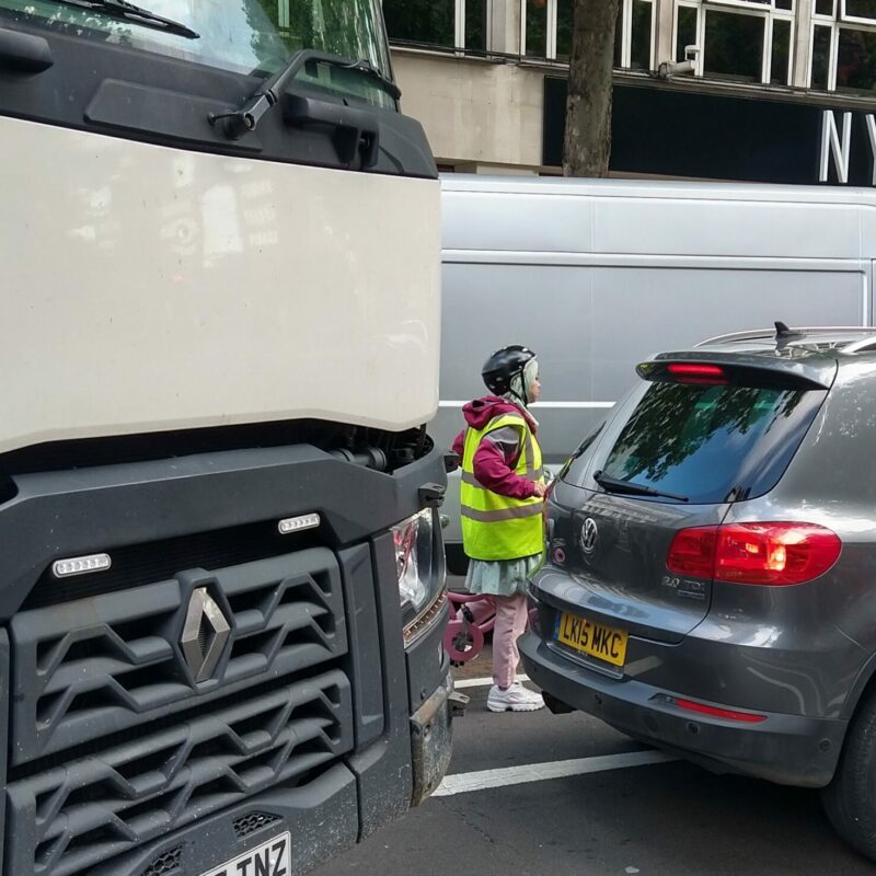 Woman cycling next to lorry at dangerous junction
