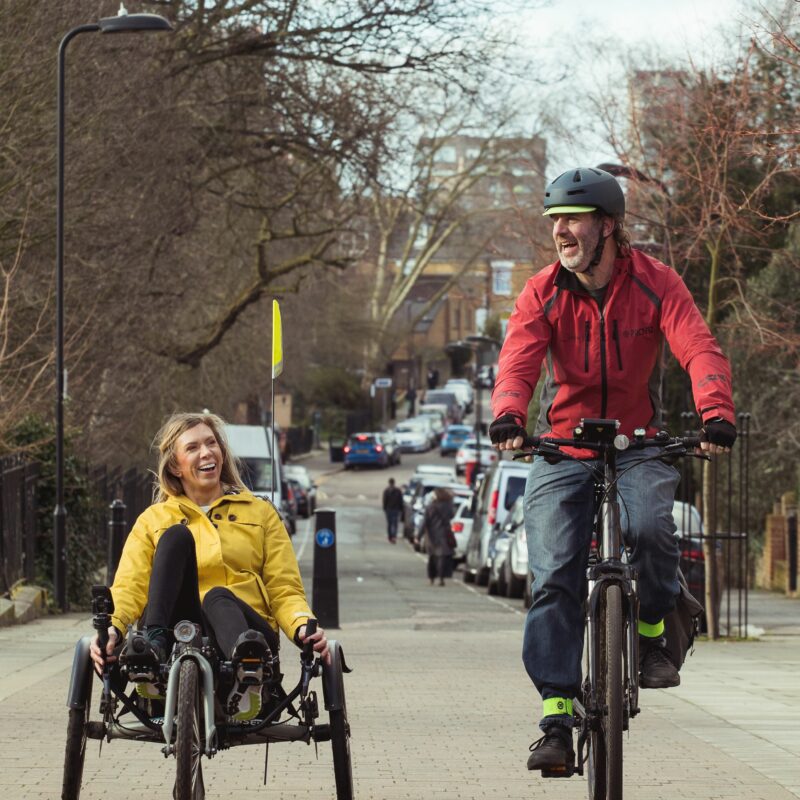 Woman on recumbant tricycle and man on bicycle