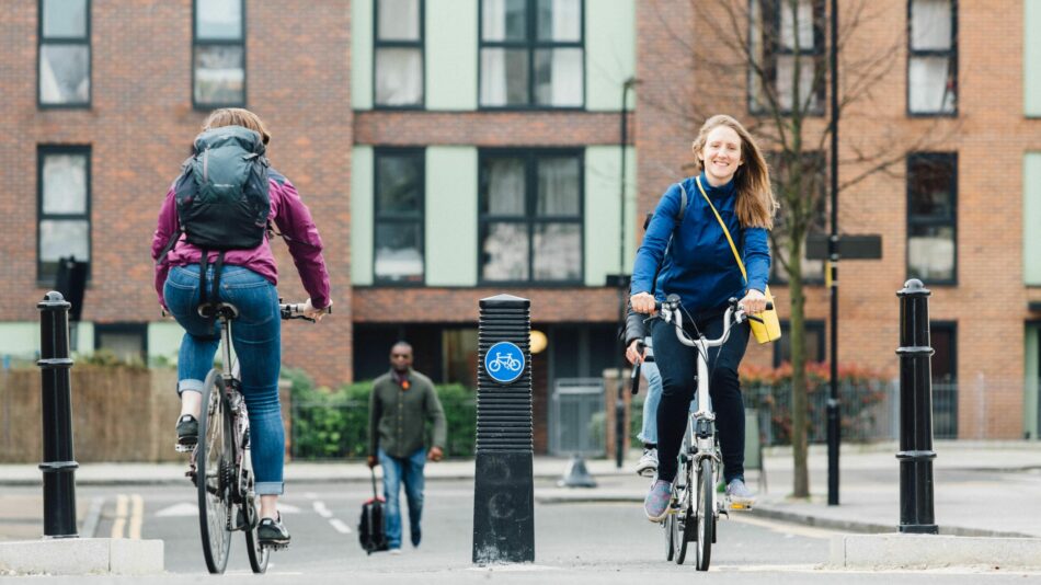 Woman cycling through bollards in Low Traffic Neighbourhood (LTN)