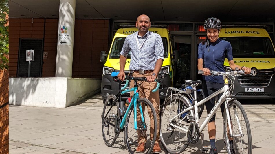 NHS staff standing with bikes in front of ambulance bay