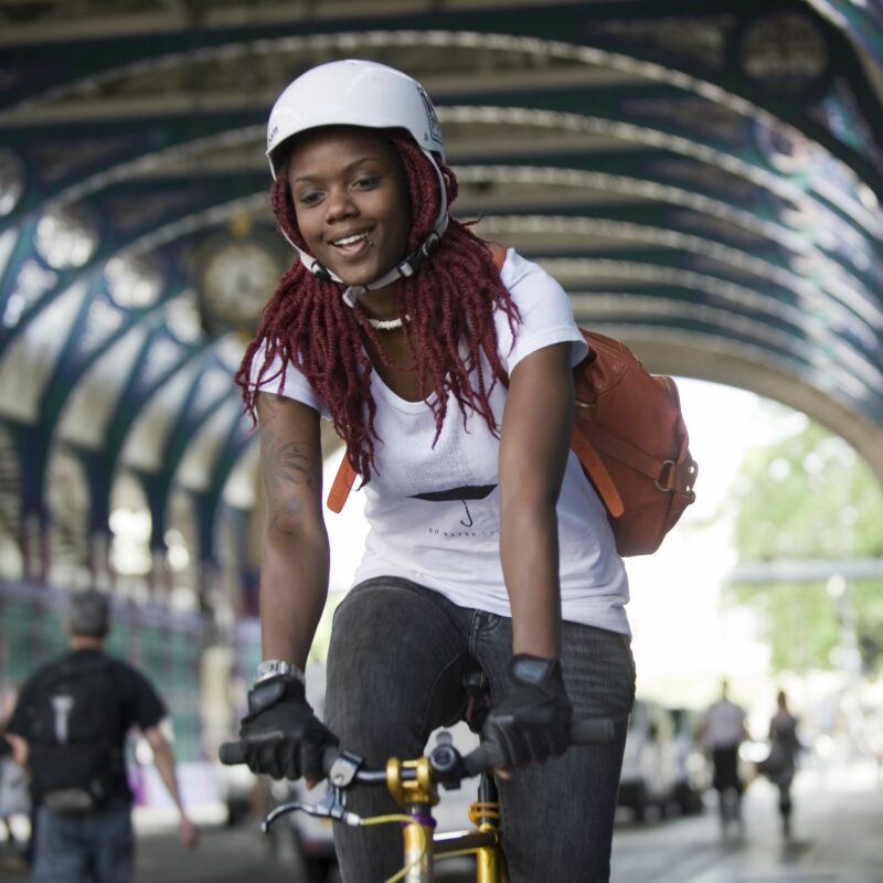 Happy woman cycling under arches