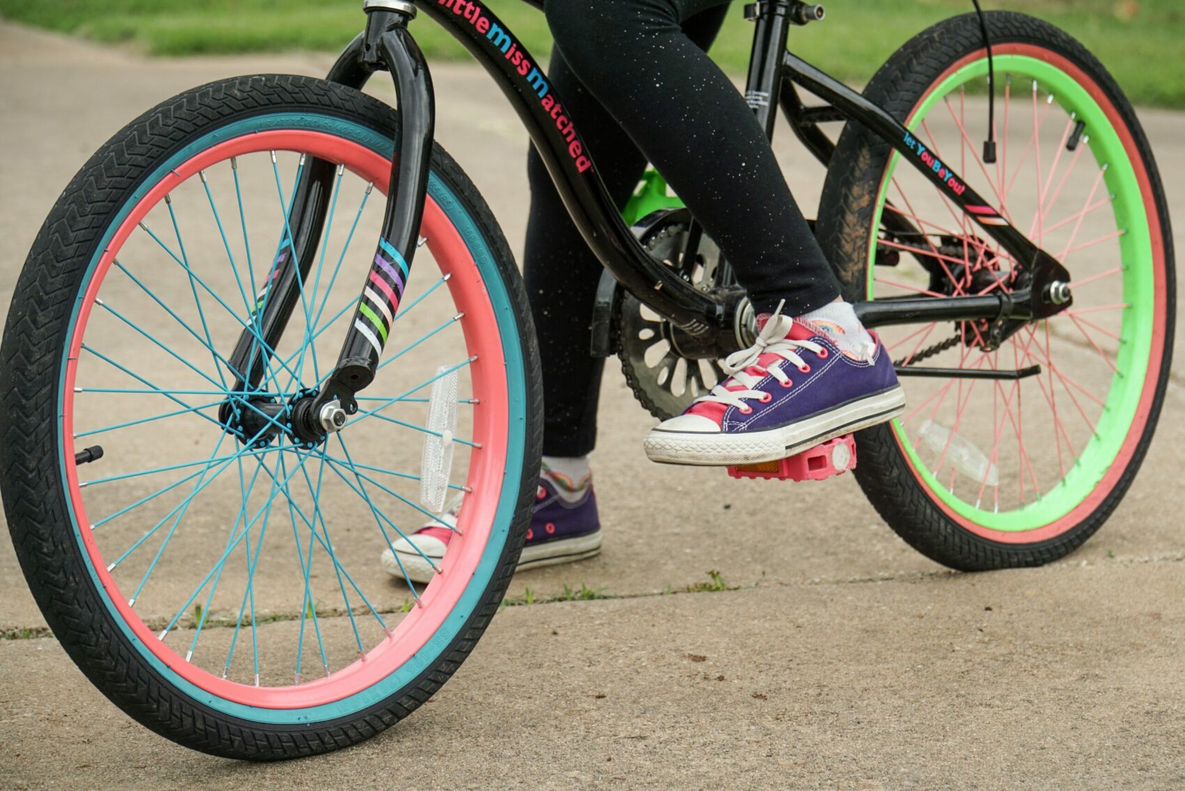 Child on colourful bike (feet only) in park